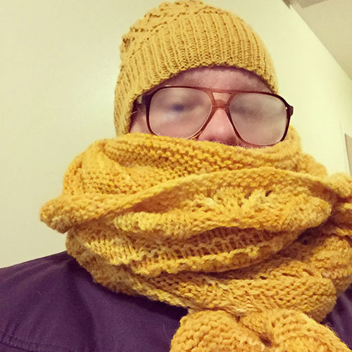 Kuvassa Tui k&auml;&auml;riytyneen&auml; keltaiseen huiviin ja pipoon