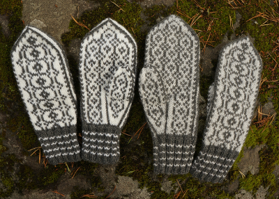 Kaksi paria valkoharmaita Riimu-kirjoneulelapasia kalliolla